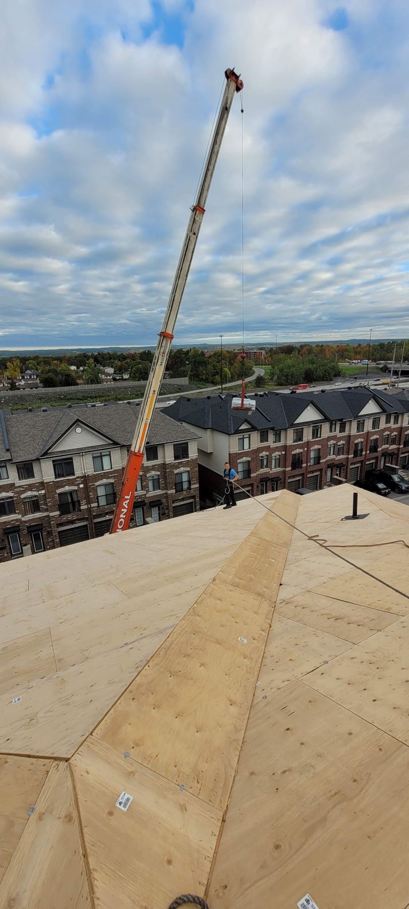 A new plywood roof deck with a crane beside it